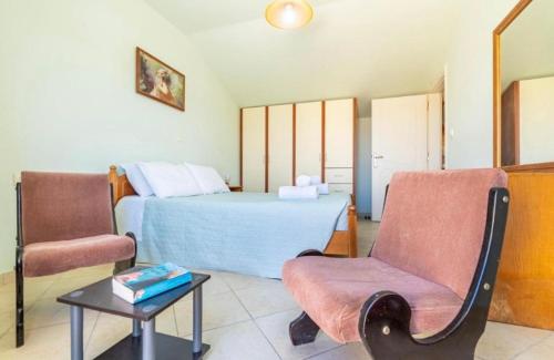 a bedroom with a bed and a chair and a table at La Soffitta di Bampina in Perivolion