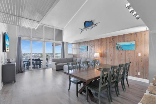 a dining room with a table and chairs and a couch at St Thomas - Waterfront Penthouse sleeps 16 w Pool & Boat Dock in Key West