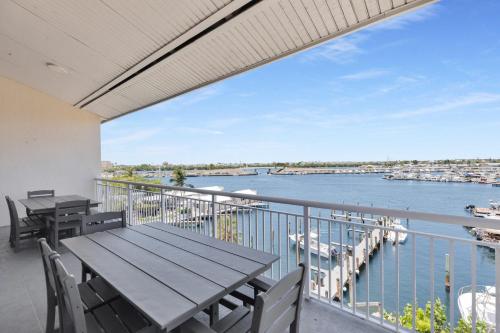 a balcony with tables and chairs and a view of the water at St Thomas - Waterfront Penthouse sleeps 16 w Pool & Boat Dock in Key West