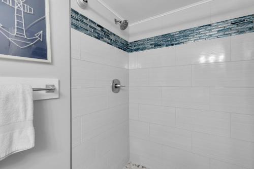 a white bathroom with a shower with a glass door at St Thomas - Waterfront Penthouse sleeps 16 w Pool & Boat Dock in Key West