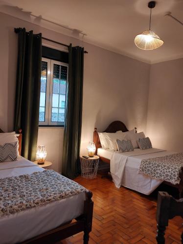 um quarto com 2 camas e uma janela em Hotel Boavista - Vintage House em Monfortinho