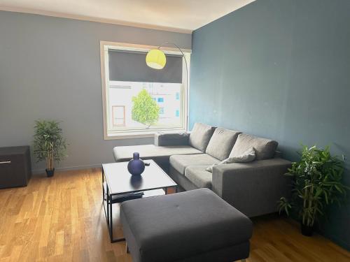 a living room with a couch and a table at Ålesund Urban - Spacious and luminous 100 m2 urban flat with 3 large bedrooms in Ålesund