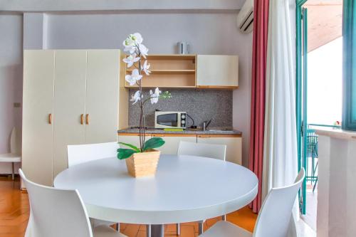 a white dining room with a white table and chairs at Residence Wieland in Torri del Benaco