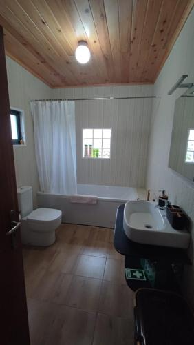 a bathroom with a toilet and a sink and a tub at Casa do Branco in Faja Grande