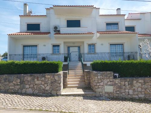 a large white house with a stone wall at Vivenda Cordeiro in Bárrio