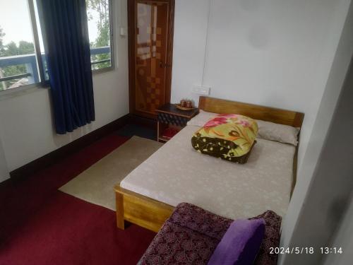 a bedroom with a bed with a pillow on it at Dawn Home Stay in Darjeeling