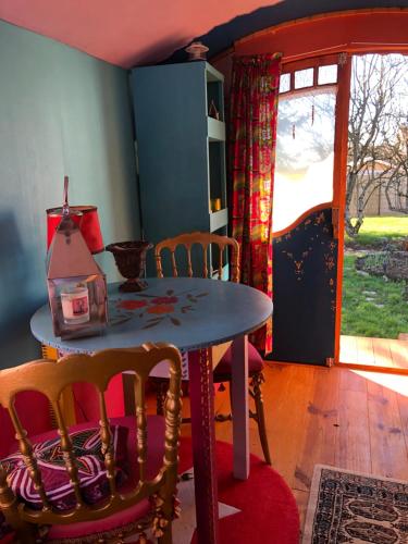a dining room with a table and chairs and a window at La roulotte de Nath in Cousance