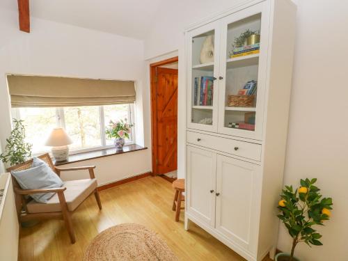 a living room with a white cabinet and a window at The Stables in Haverfordwest
