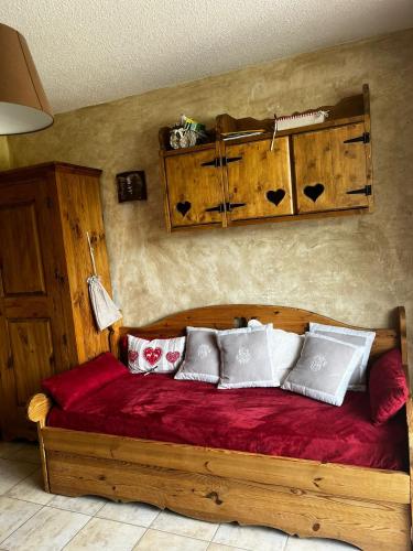 - une chambre avec un lit en bois et des oreillers dans l'établissement Résidence Veronica, à Châtel