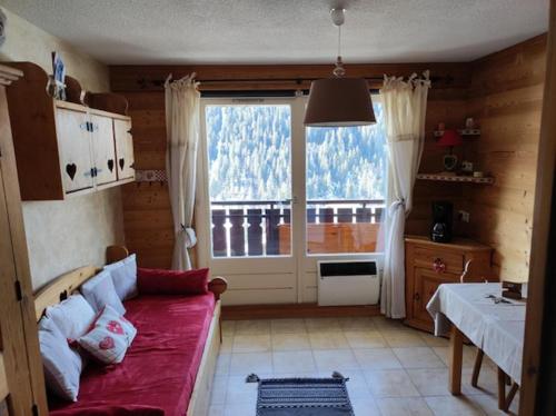 un salon avec un canapé et une grande fenêtre dans l'établissement Résidence Veronica, à Châtel