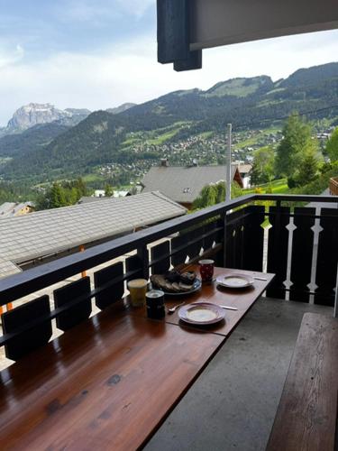 une table avec des assiettes de nourriture au sommet d'un balcon dans l'établissement Résidence Veronica, à Châtel