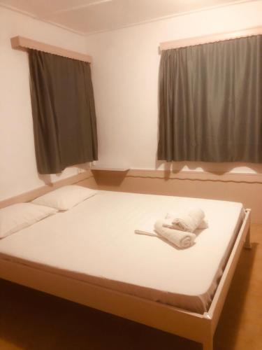 a bed in a room with a white mattress at Barreira Beachfront Rooms 4 in Kalamata