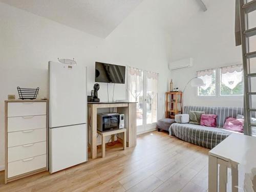 - un salon avec un réfrigérateur et un canapé dans l'établissement MAISONNETTE KALIS CALME avec CLIMATISATION PARKING JARDIN CADRE CAMPAGNE plages à pieds, à Bandol