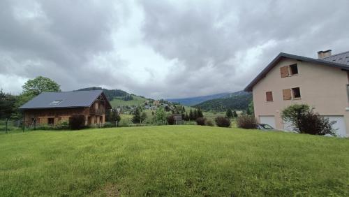 a house on a hill with a green field at Chalet 12 places dans le Vercors in Corrençon-en-Vercors
