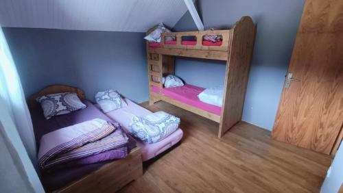 a small room with two bunk beds and a door at Chalet 12 places dans le Vercors in Corrençon-en-Vercors