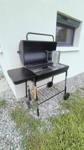 a grill sitting on a table next to a building at Chalet 12 places dans le Vercors in Corrençon-en-Vercors