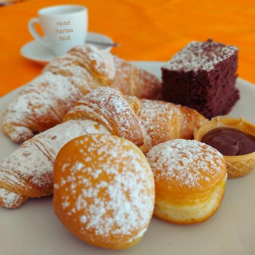 a plate of pastries and a cup of coffee at Hotel Patrizia - B&B e Appartamenti in Bellaria-Igea Marina
