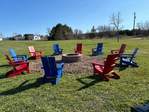 a group of colorful chairs sitting in a field at Sundance Cottages in Cavendish