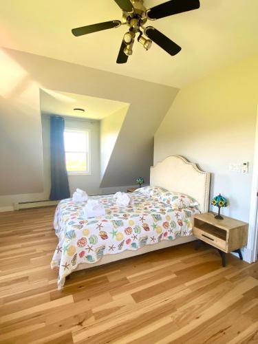 a bedroom with a bed and a ceiling fan at Sundance Cottages in Cavendish