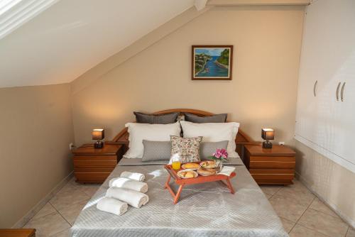a bedroom with a bed with a tray of food on it at Villa Regina By The Sea in Epanomi