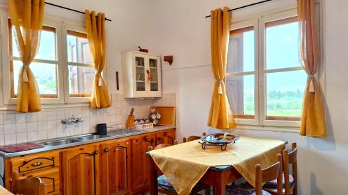 una cucina con tavolo, lavandino e finestre di Gaia Estate a Calimno (Kalymnos)