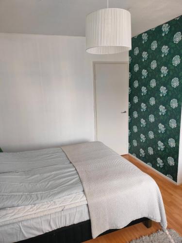 a bedroom with a bed and a wall with flowers at Railway&bus station studio in Oulu