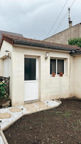 une maison avec une porte blanche et deux fenêtres dans l'établissement Studio Le Mans, au Mans