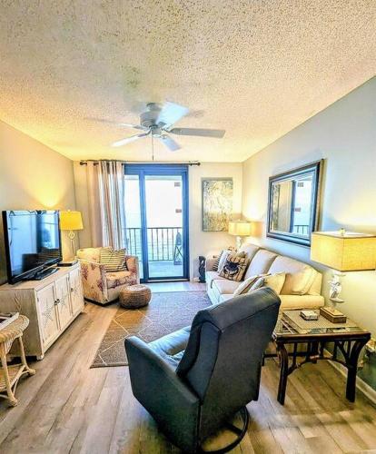 a living room with a couch and a tv at Beachfront Bliss-Phoenix II in Orange Beach
