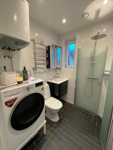 uma casa de banho com um WC e uma máquina de lavar roupa em Minihus i Enskede-Årsta-Vantörs em Estocolmo