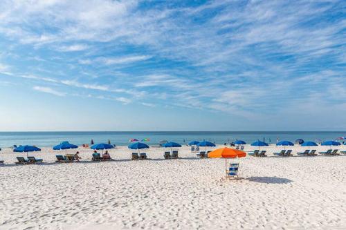 a beach with umbrellas and chairs and the ocean at Beachfront Bliss-Phoenix II in Orange Beach