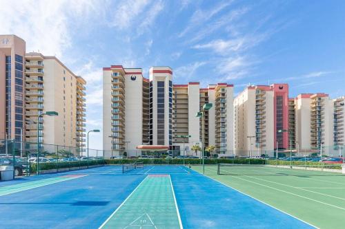 a tennis court in front of some buildings at Beachfront Bliss-Phoenix II in Orange Beach