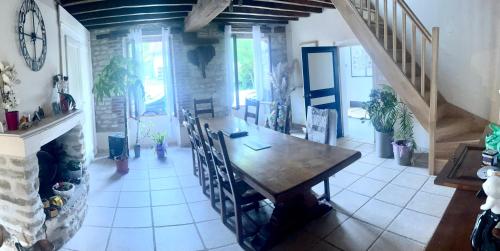 une salle à manger avec une table et des chaises en bois dans l'établissement La maison du retour aux sources, à Montigny-les-Monts