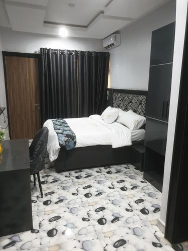 a bedroom with a bed and a table and a chair at Downunder suites in Gwarinpa