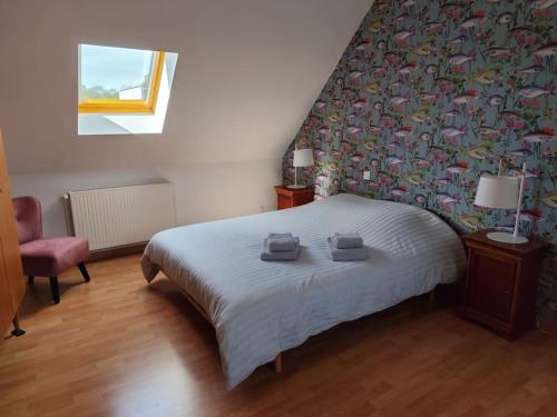 une chambre avec un lit avec deux serviettes dessus dans l'établissement La Muche Valéricaine, coeur de ville, jardin, à Saint-Valery-sur-Somme