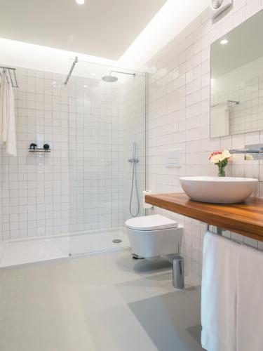 a white bathroom with a sink and a toilet at Quinta da Casa Grande in Ponta Delgada