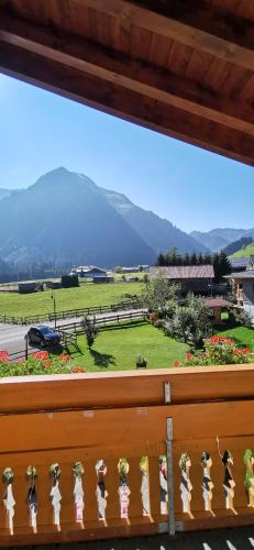 a window with a view of a field and mountains at Landhaus Thaler in Mittelberg