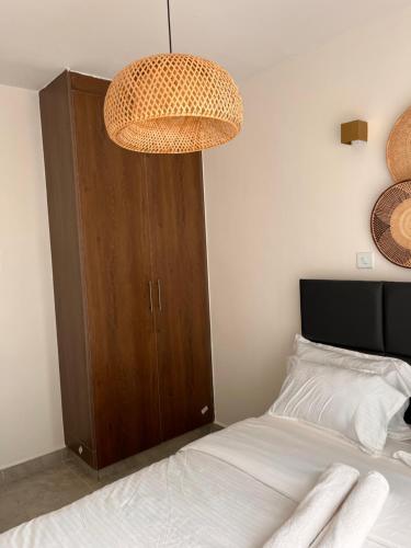 a bedroom with a bed and a wooden cabinet at Gem by T in Rongai with a pool in Ongata Rongai 