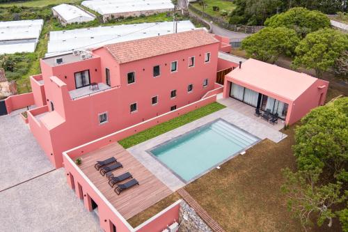 an aerial view of a pink house with a swimming pool at Quinta da Casa Grande in Ponta Delgada