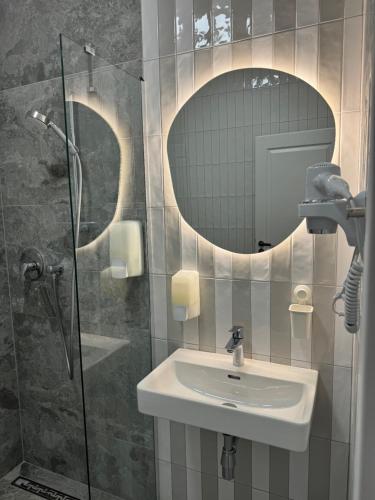 La salle de bains est pourvue d'un lavabo et d'un miroir. dans l'établissement Apartmánový Dům Centrum, à Brno