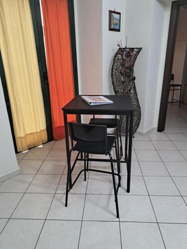 uma mesa preta com duas cadeiras e uma mesa em Antonia & Ivano em Salerno