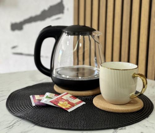 a coffee pot and a cup on a table at Hotel Turist 98 in Jajce