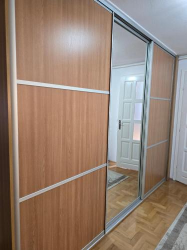a closet with wooden doors and a mirror at Villa Amir in Sarajevo