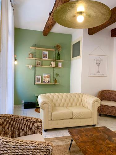 - un salon avec un canapé et un mur vert dans l'établissement Maison spacieuse et calme, Centre Ville, Idéal Famille, à Perpignan