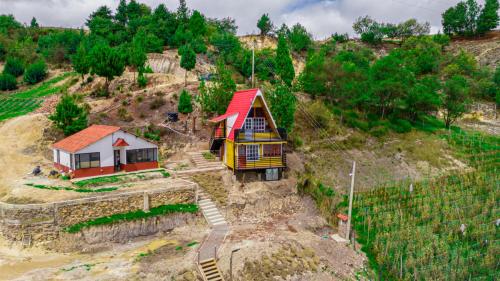 a small house with a red roof on a hill at Chalet-Familiar Tota, full-equipado! CLIMATIZADO! in Tota