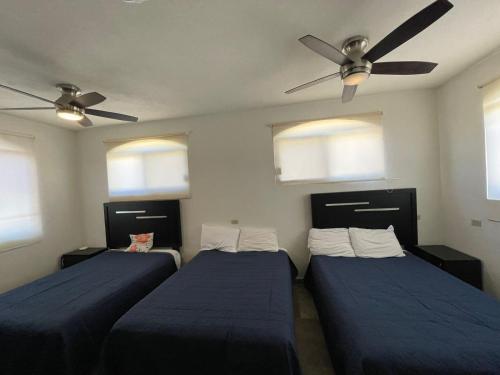 a bedroom with two beds and a ceiling fan at Hostal las Quintas in San José del Cabo