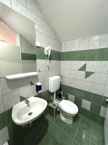 a bathroom with a toilet and a sink at Rooms ALEA in Sanski most