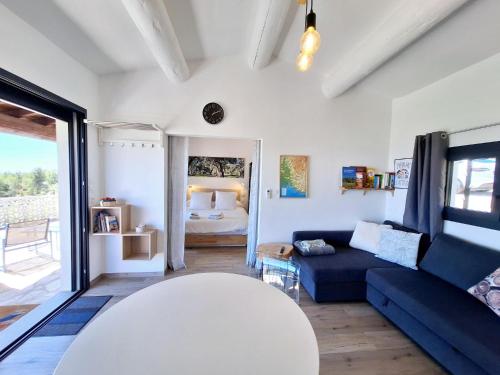 un salon avec un canapé bleu et une chambre dans l'établissement mas benette, à Saint-Hippolyte-le-Graveyron
