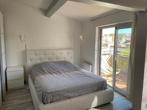 une chambre avec un lit et une grande fenêtre dans l'établissement Appart Centre Mairie - Terrasse vue Ste Victoire, à Aix-en-Provence