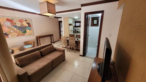 a living room with a couch and a dining room at Apartamento Cachalote - Terraces Porto das Baleias - Praia do Forte in Praia do Forte