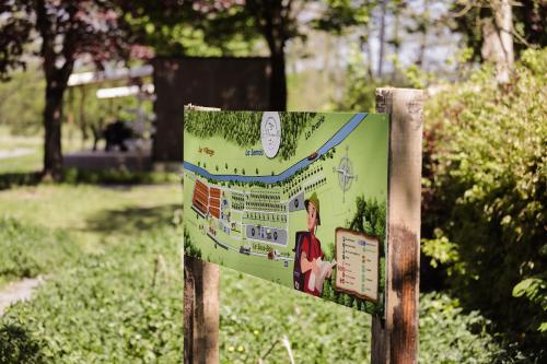 a sign in a park next to some bushes at Camping Le Florenville in Florenville